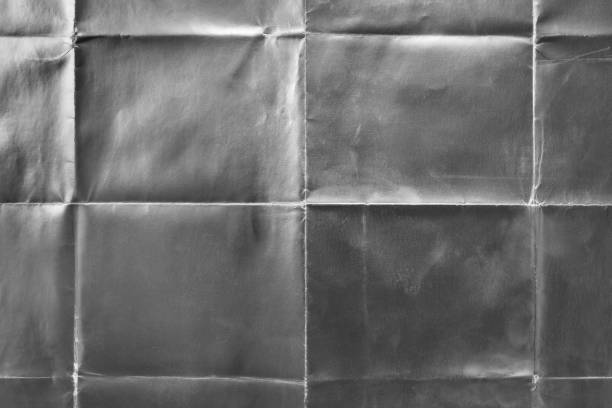 istock Old silver gift wrapping paper with creases 1054696400