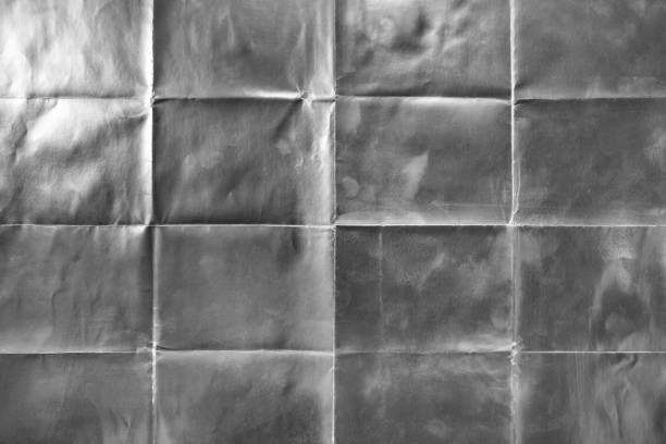 istock Old silver gift wrapping paper with creases 1054701306