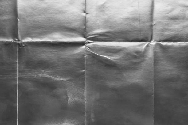 istock Old silver gift wrapping paper with creases 1054704856