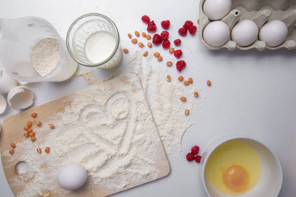 istock Cooking yeast dough for buns, butter, eggs, cooking equipment, flour on a wooden table. raspberry, sea-buckthorn. Top view with copy space, mockup for menu, recipe or culinary classes. 1054704970