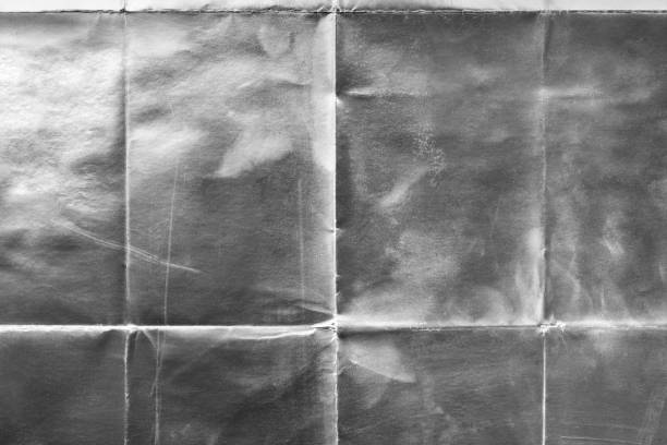 istock Old silver gift wrapping paper with creases 1054713086