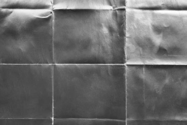 istock Old silver gift wrapping paper with creases 1054713852