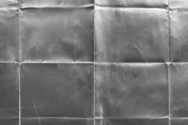 istock Old silver gift wrapping paper with creases 1054715770