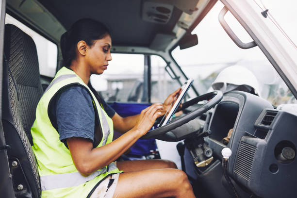 istock Construction industry worker texting on the digital tablet inside a truck. 1054724786