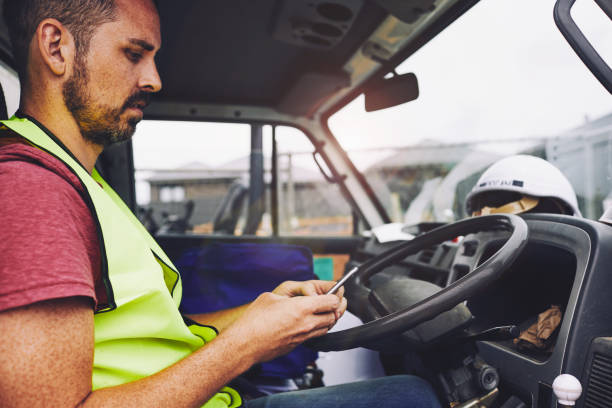 istock Construction industry worker texting on the phone inside a truck. 1054724792