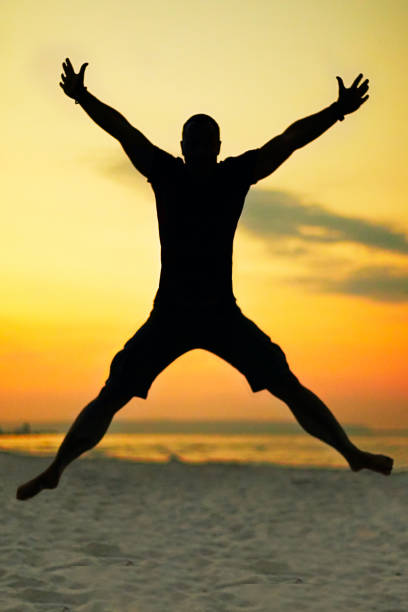 istock X Silhouette of a jumping man on the beach 1054727904