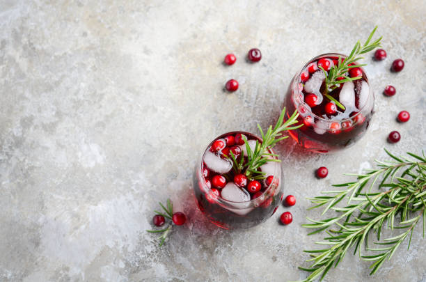 istock Cold refreshing drink with cranberries and rosemary on a gray concrete background 1054739894