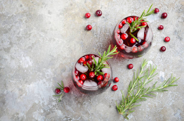 istock Cold refreshing drink with cranberries and rosemary on a gray concrete background 1054739918