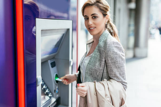 istock Electronic banking in England - woman using AT cash point 1054745206