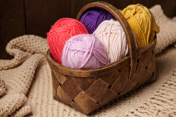 istock colorful wool threads for knitting in basket, wooden background 1054750050