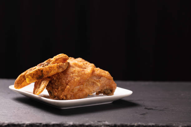 One piece of fried chicken with potato wedges on the side