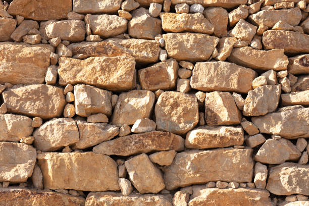 istock wall of irregular yellow stones 1054753794