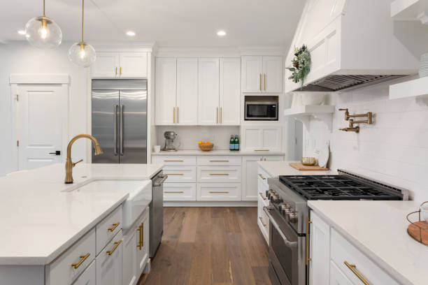 mooie keuken in nieuwe luxe huis met island, hanger lichten en hardhoutvloeren - luxe stockfoto's en -beelden
