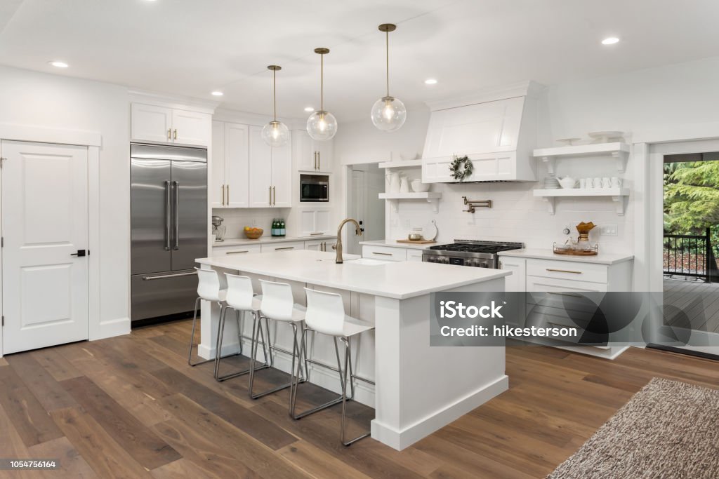 hermosa cocina en casa con isla, Lámparas colgantes y pisos de madera de lujo nuevo - Foto de stock de Cocina - Estructura de edificio libre de derechos