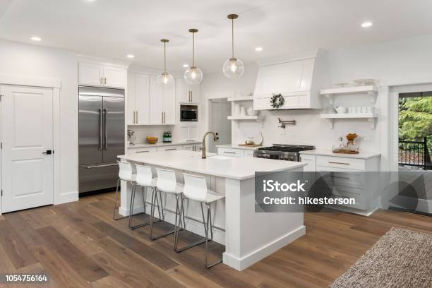 Hermosa Cocina En Casa Con Isla Lámparas Colgantes Y Pisos De Madera De Lujo Nuevo Foto de stock y más banco de imágenes de Cocina - Estructura de edificio