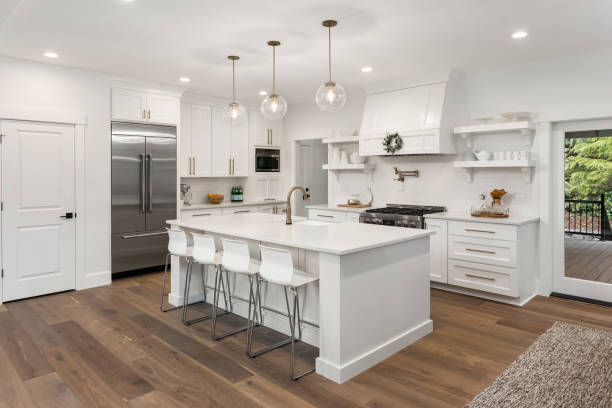 beautiful kitchen in new luxury home with island, pendant lights, and hardwood floors kitchen in newly constructed luxury home pendant photos stock pictures, royalty-free photos & images