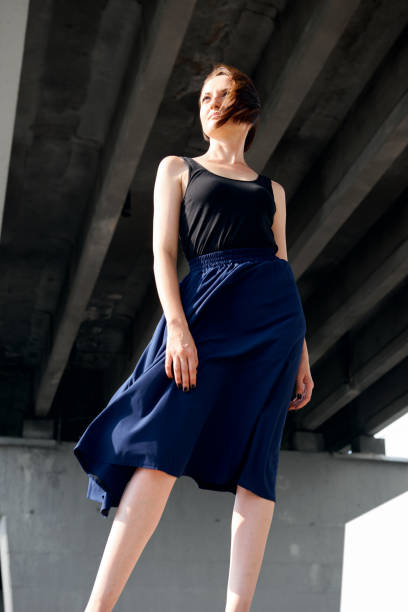 istock young girl posing under the bridge, dressed in black, modern architecture 1054758196