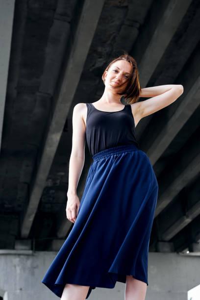 istock young girl posing under the bridge, dressed in black, modern architecture 1054758262