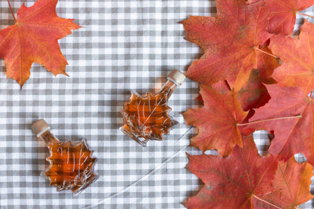 jarabe de arce en una botella en forma de hoja de maple. - japanese maple autumn leaf tree fotografías e imágenes de stock