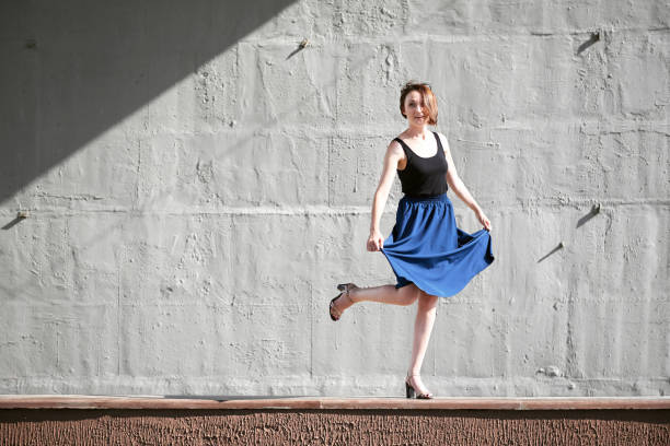 istock young girl posing against a concrete wall, dressed in black, hard light and shadows 1054761546