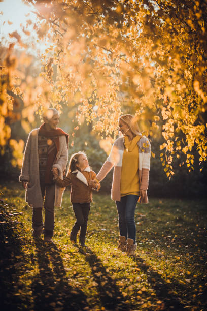 happy female members of extended family taking a walk in autumn day. - grandmother senior adult child multi generation family imagens e fotografias de stock