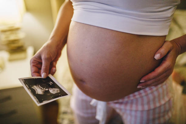 istock Pregnant woman at home with a x-ray image 1054775910