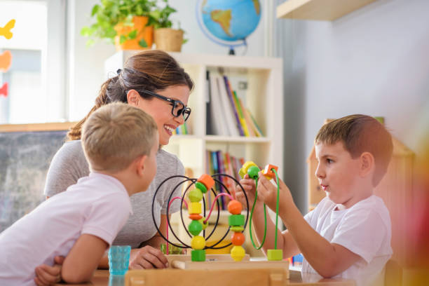 istock Preschool teacher with children playing with didactic toys 1054776348