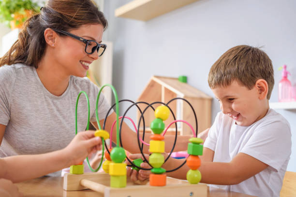 istock Preschool teacher with children playing with didactic toys 1054777704