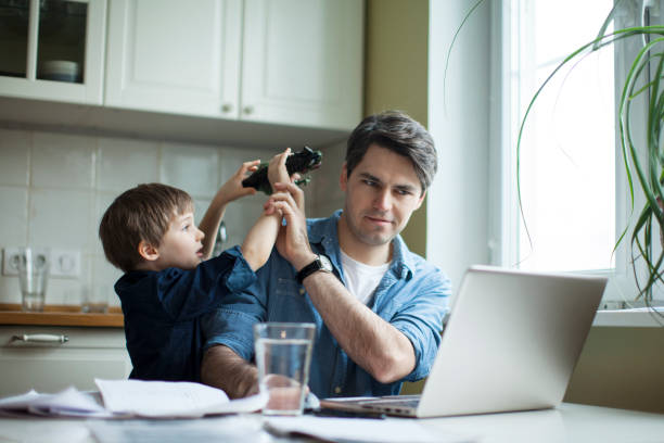 istock Little son disturbing working freelancer father 1054778280