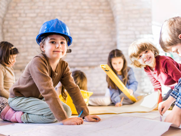 istock Smiling little architect working with friends in the office. 1054778322