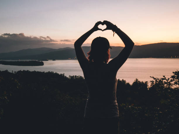 istock Heart Shape with Hands Female Hiker Watching Sunset Over Lake 1054779342