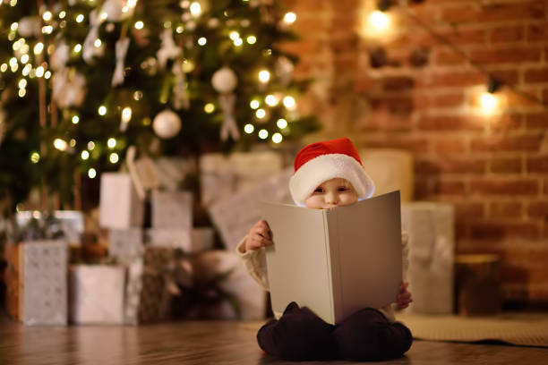 istock Little boy reading a magic book in decorated cozy living room 1054784792