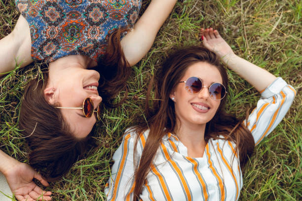istock two female friends lying on grass 1054784950