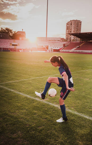 istock Determined female soccer player practicing with ball on the field. 1054786836