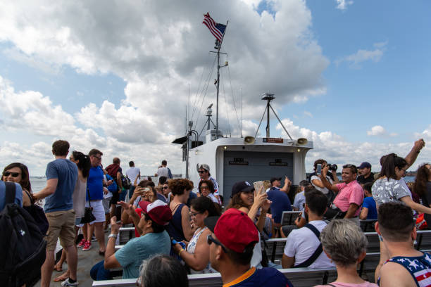 ニューヨーク/米国 - 2018 年 8 月 22 日: 晴れた日の自由の女神へのフェリーの写真を取る人 - crown liberty statue ストックフォトと画像