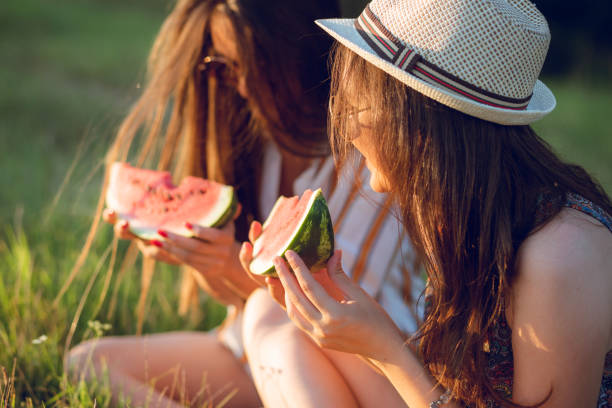 istock Two women eating watermelon outside 1054787788