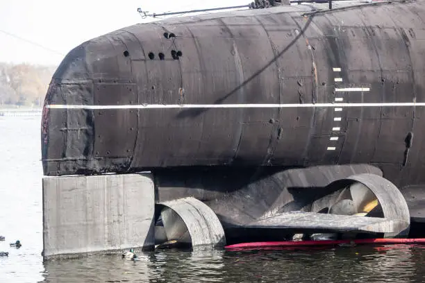 Ducks swim on the background of the engine of the Russian submarine. Rowing propellers sea ship.