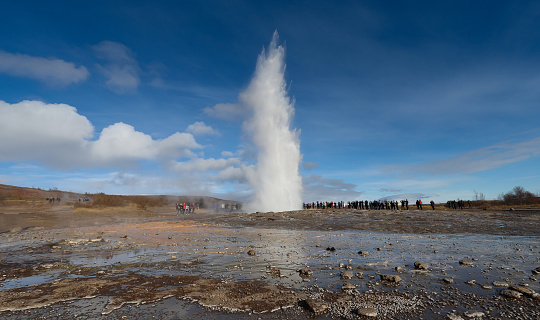 Tourists watching eruption of Strokkur geyser on Iceland