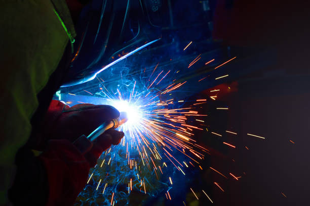 las chispas durante la soldadura en el proceso de producción de soldadura semi automática de metales en los gases de protección argón - industrial ship flash fotografías e imágenes de stock