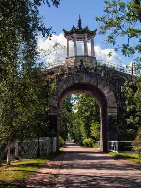 Photo of Stone bridge tunnel over the road with a Chinese-style gazebo in the Alexander Park in Tsarskoye Selo in St. Petersburg