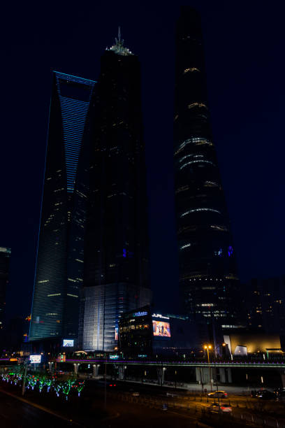 three supertall skyscrapers in lujiazui at night - china shanghai city shopping imagens e fotografias de stock