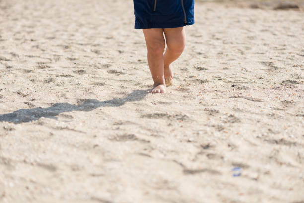 istock Baby feets on the sea sandy beach 1054805418