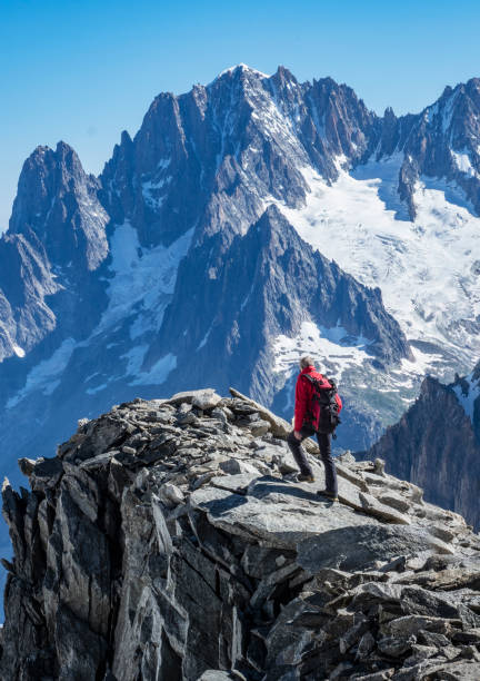 alpinista sobre uma saliência rochosa - courmayeur european alps mont blanc mountain - fotografias e filmes do acervo
