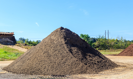 Mound of black Soil used for landscaping and driveways on display and for sale.