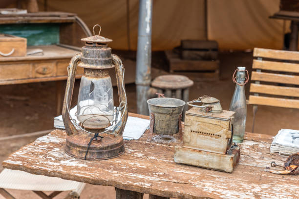 istock camping tent, old wooden table with explorer utensils 1054828746