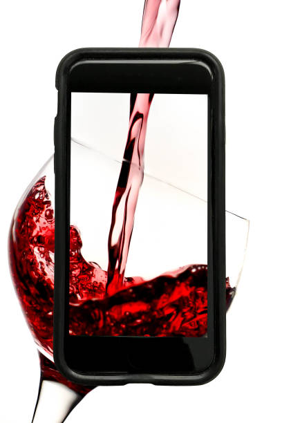 copa vino rojo sobre fondo blanco en la pantalla de un teléfono - wine pouring wineglass red fotografías e imágenes de stock