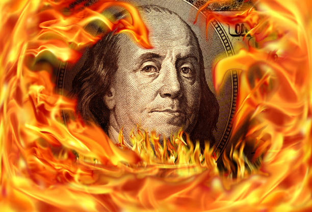istock Conceptual finance image of burning dollar bill and fire flames 1054848074