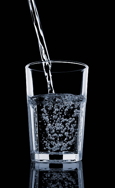 Pouring a Glass of Water - Isolated on Black