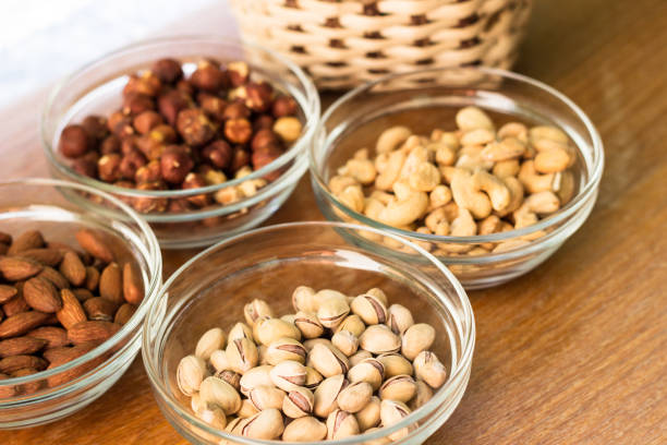 istock Assortment of mixed nuts and wicker basket on wood table background 1054848198