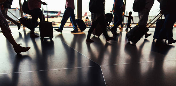 silhouette der passagiere zu fuß durch flughafen flur mit gepäck - airport usa business ohare airport stock-fotos und bilder